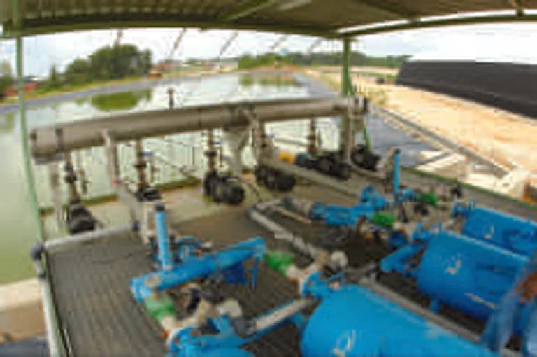 Pump and motor room with blue-painted pump units and piping.