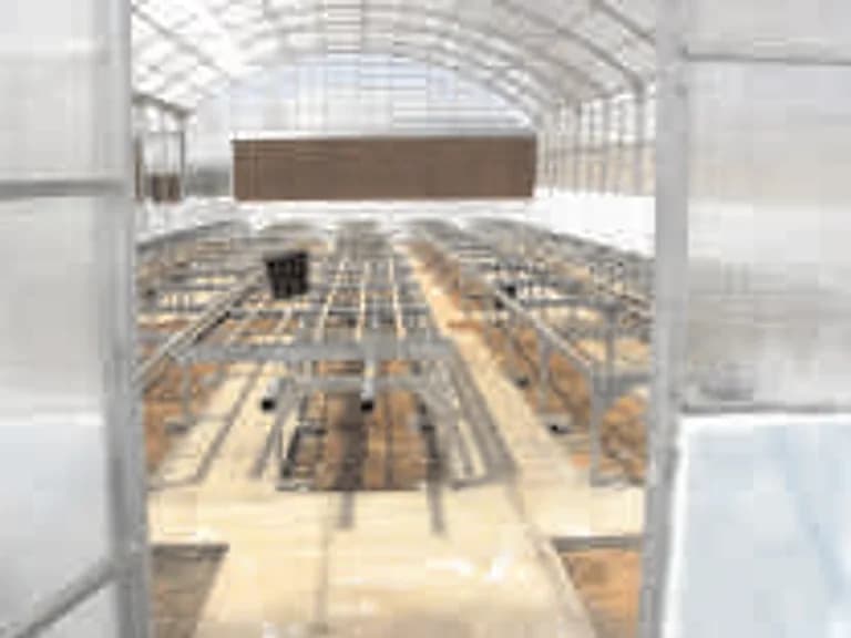 Interior structural framework of a poly house under construction, benches.