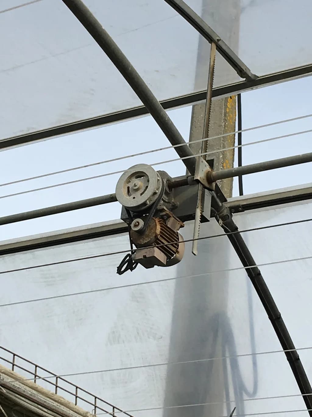 Roof ventilation winch mechanism mounted at the polyhouse roof structure.
